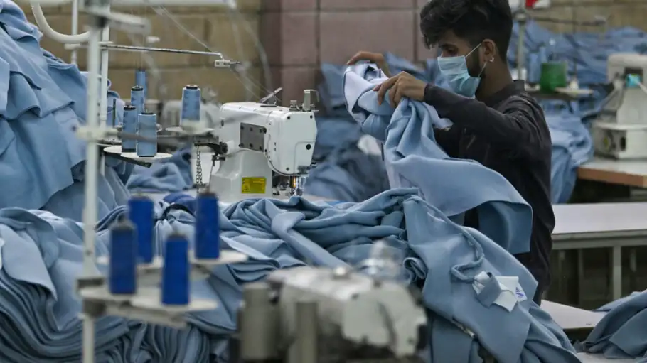 Sewing operator working on blue denim garments, garment factory in Dhaka, Bangladesh, DRESSOURCE