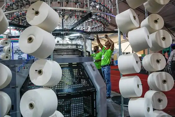 Yarn cones feeding industrial knitting machines at a knit fabric mill, Bangladesh, DRESSOURCE partner factory