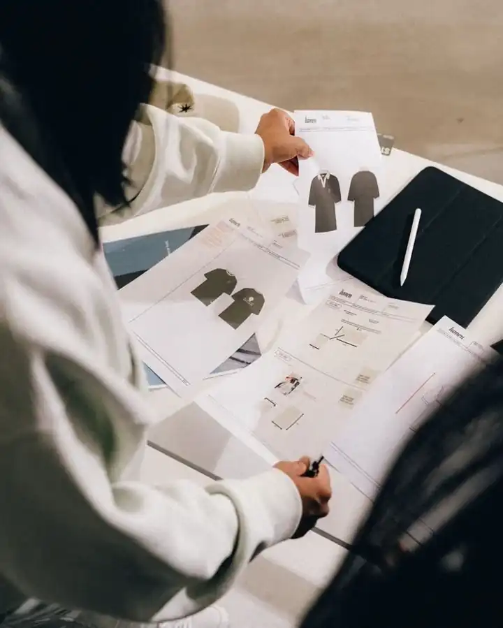 Designer reviewing tech pack sketches and garment samples, product development and sampling service, DRESSOURCE