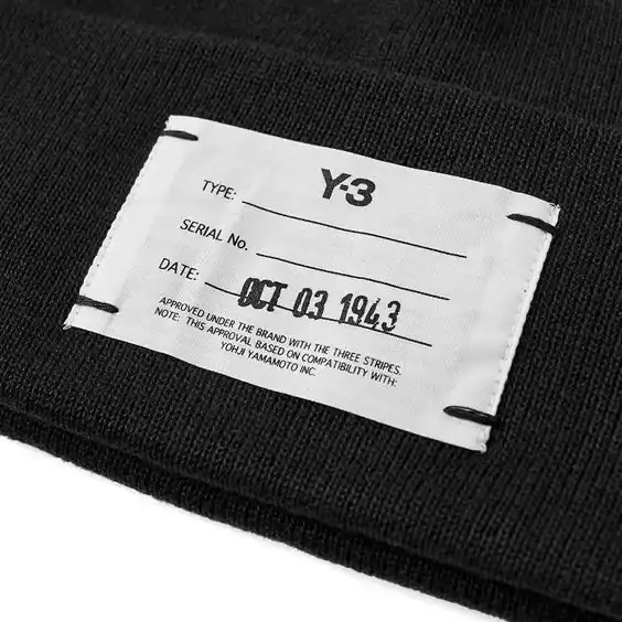 Woven private label on a black knit garment, private label clothing manufacturing, DRESSOURCE